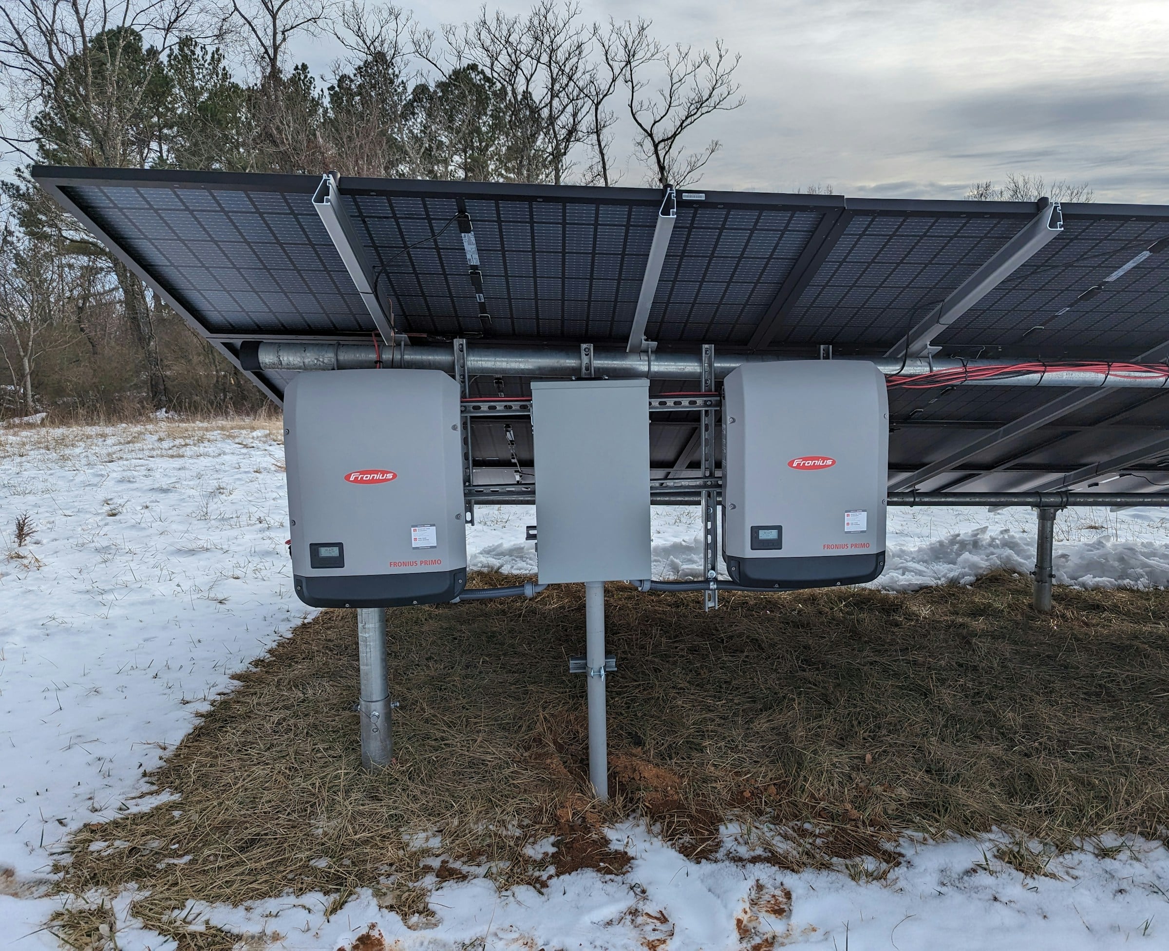 String inverters mounted beneath a ground solar array