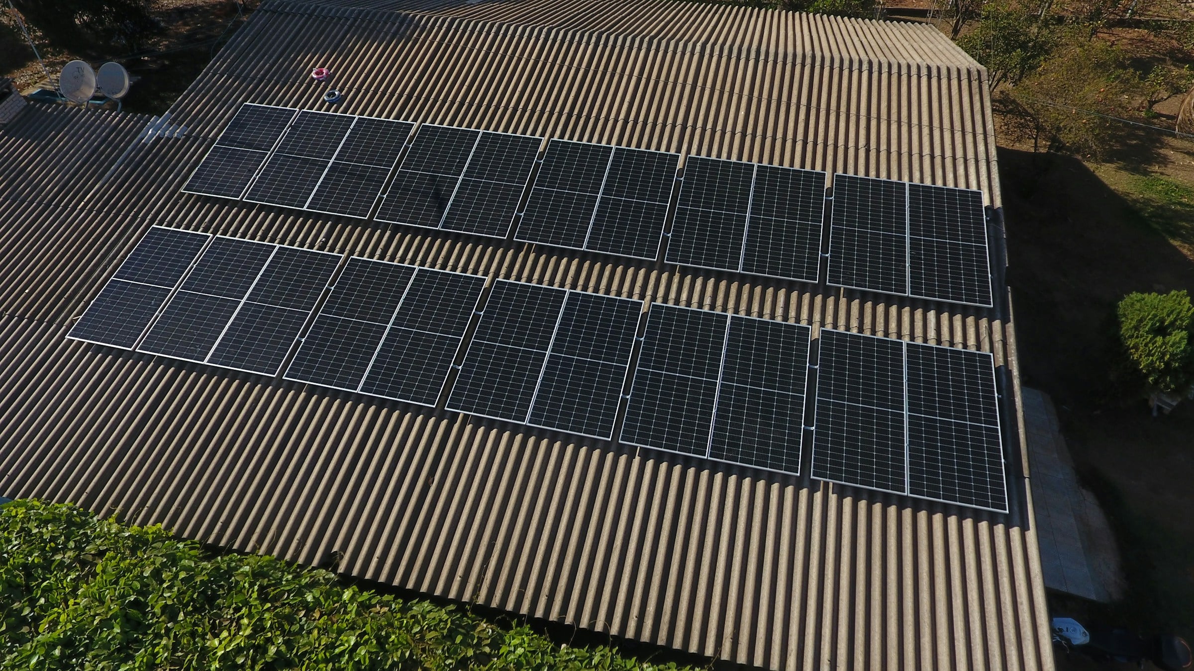 Rooftop solar panels on a corrugated roof in late afternoon sun